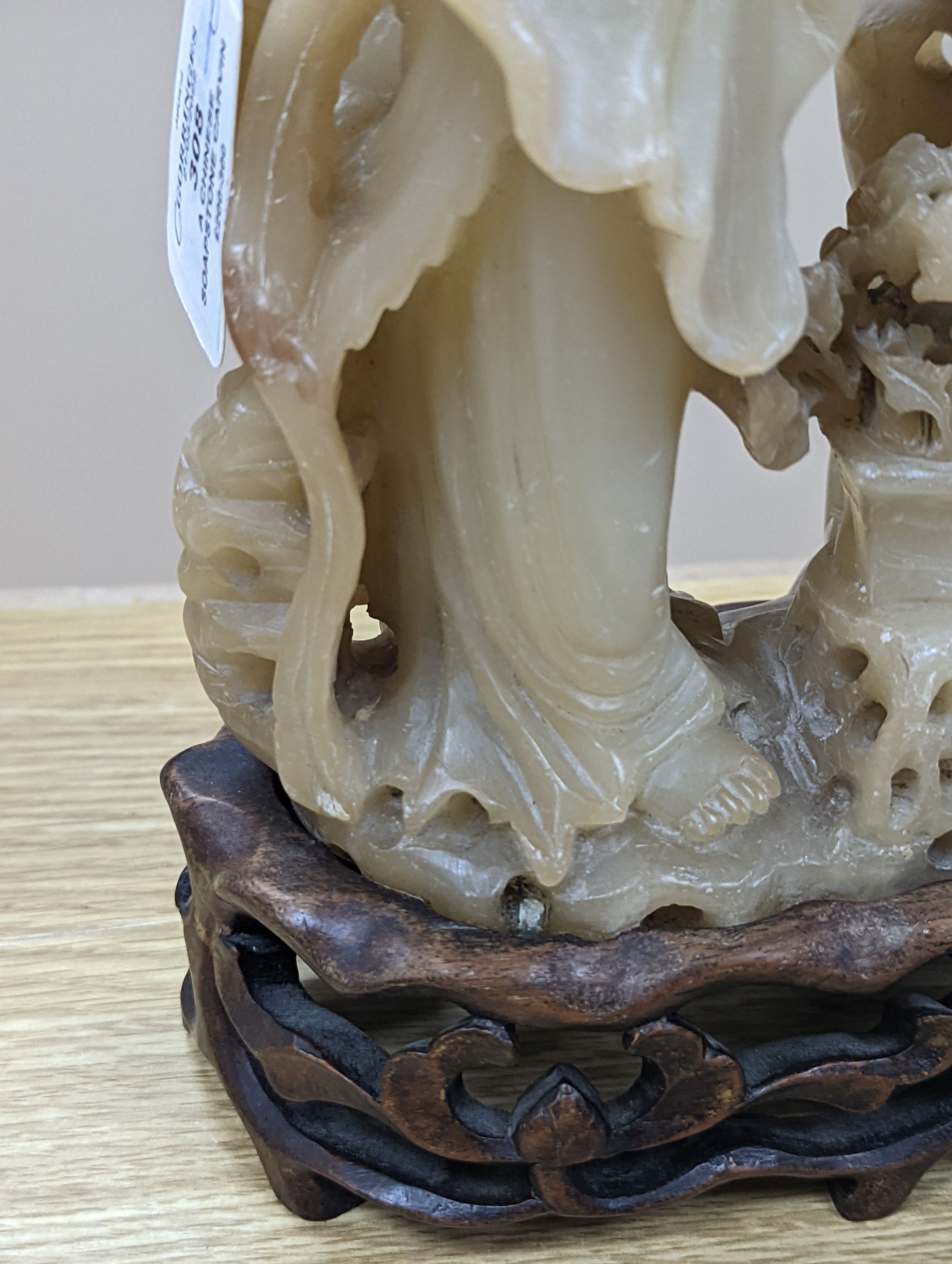 A Chinese soapstone carving of two ladies, wood stand, early 20th century, 36 cms high.